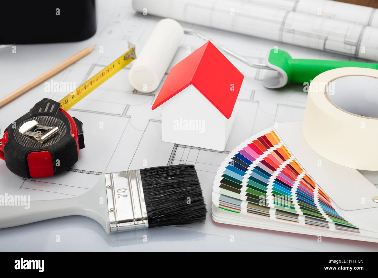 High Angle View Of House Model With Blueprint And Other Materials On Office Desk Stock Photo