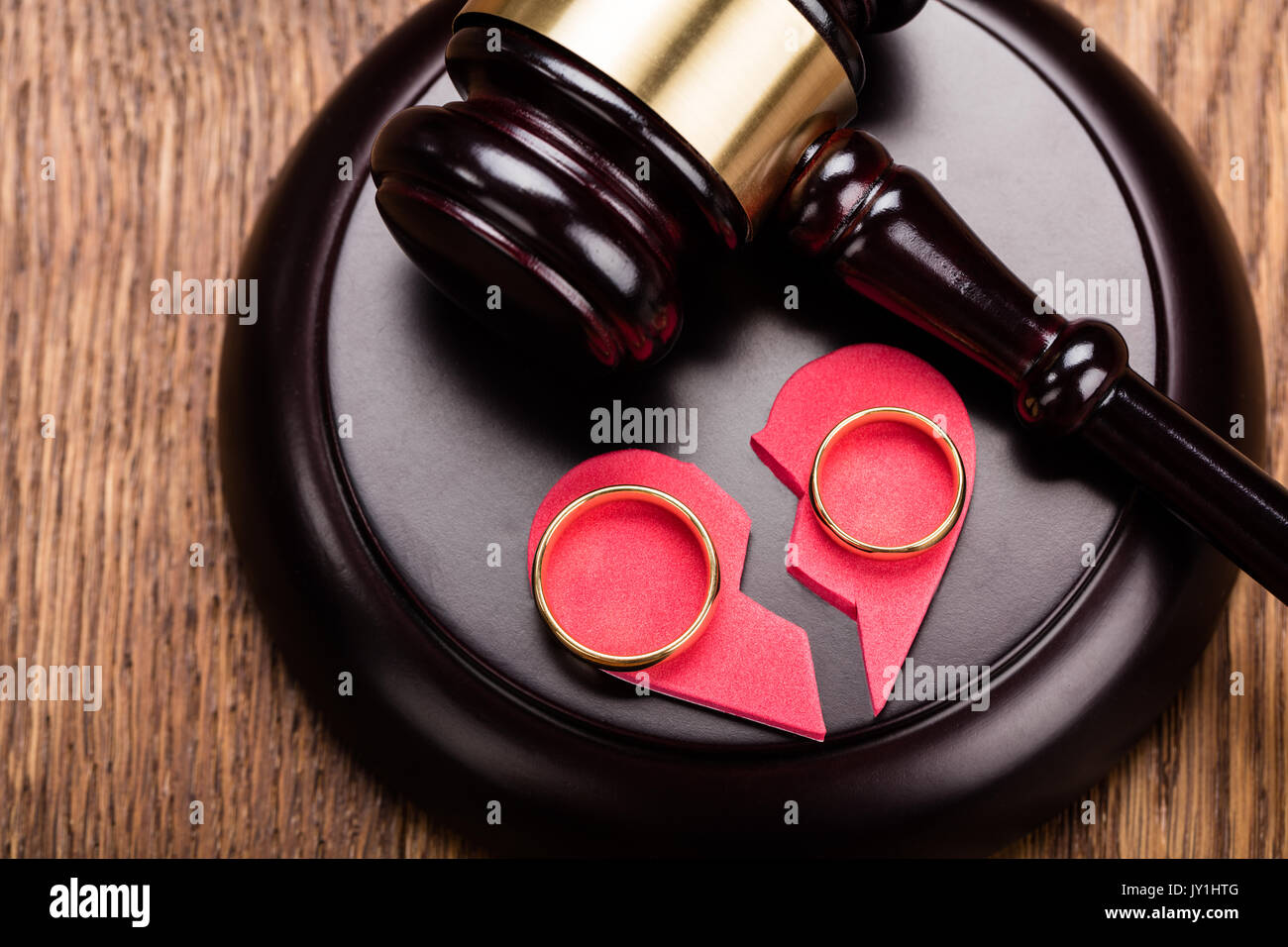 High Angle View Of Golden Ring On Red Broken Heart At Wooden Gavel In Court Stock Photo