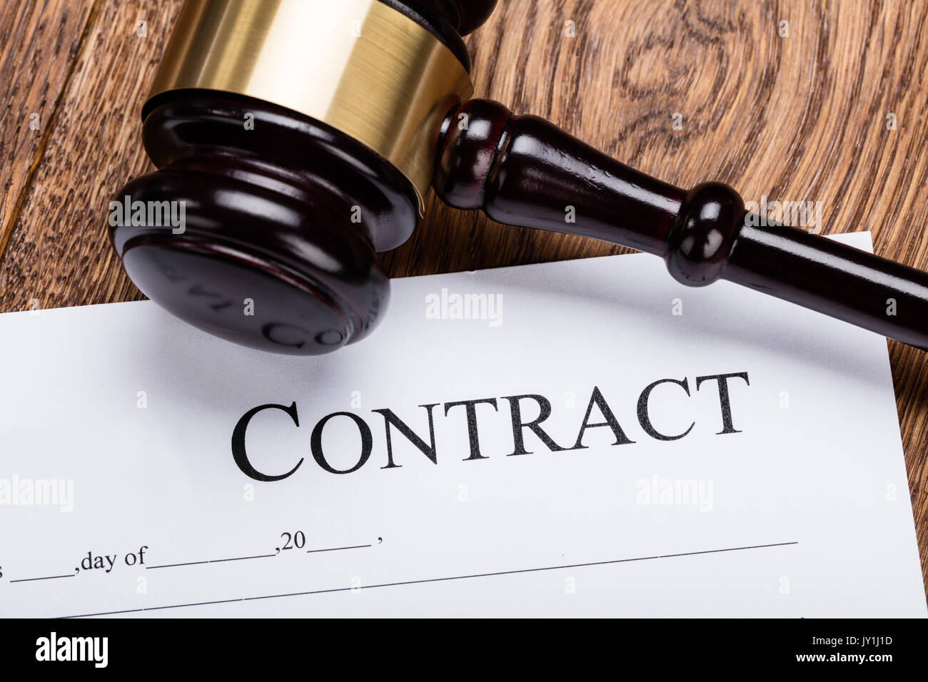 High Angle View Of Wooden Gavel On Contract Paper Stock Photo