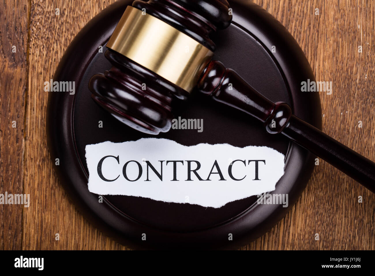 High Angle View Of Contract Word Written On Gavel At Wooden Desk In Court Stock Photo