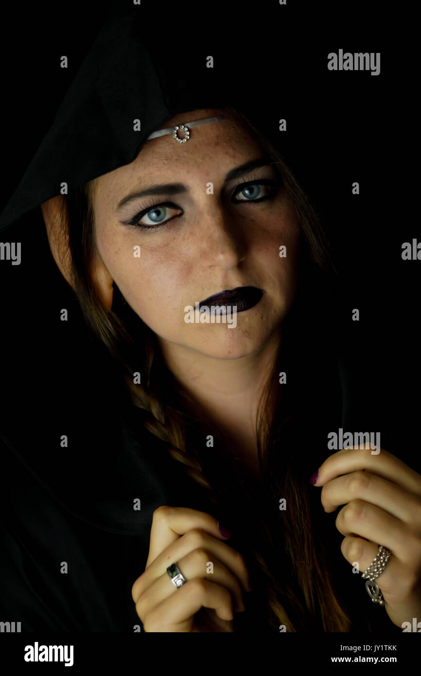 A young woman dressed as an elf with a black hooded robe and long hair