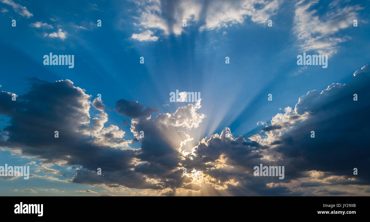 Sun projecting rays from behind the clouds. Stock Photo