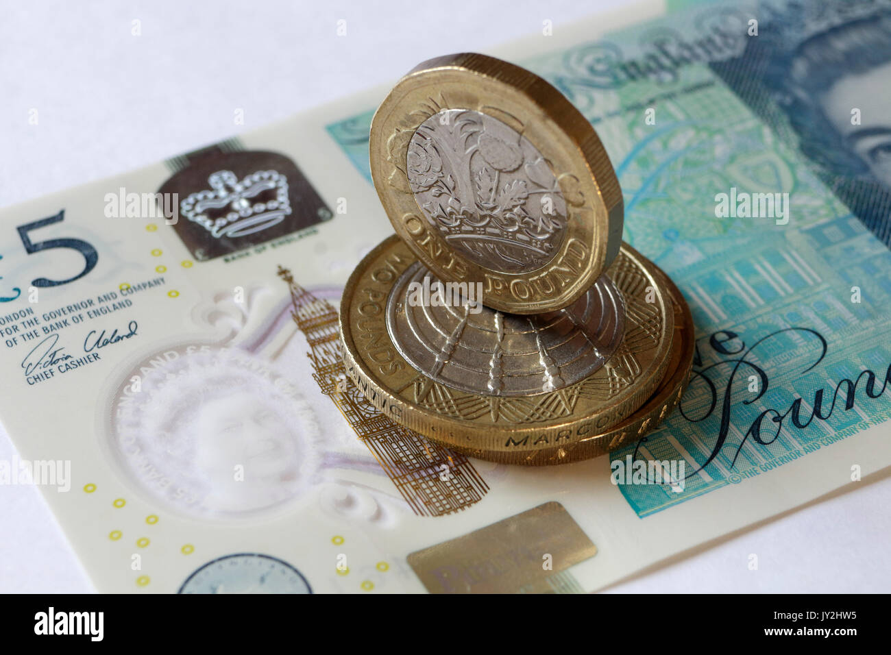 NewBritish Pound coin and five pound note Stock Photo
