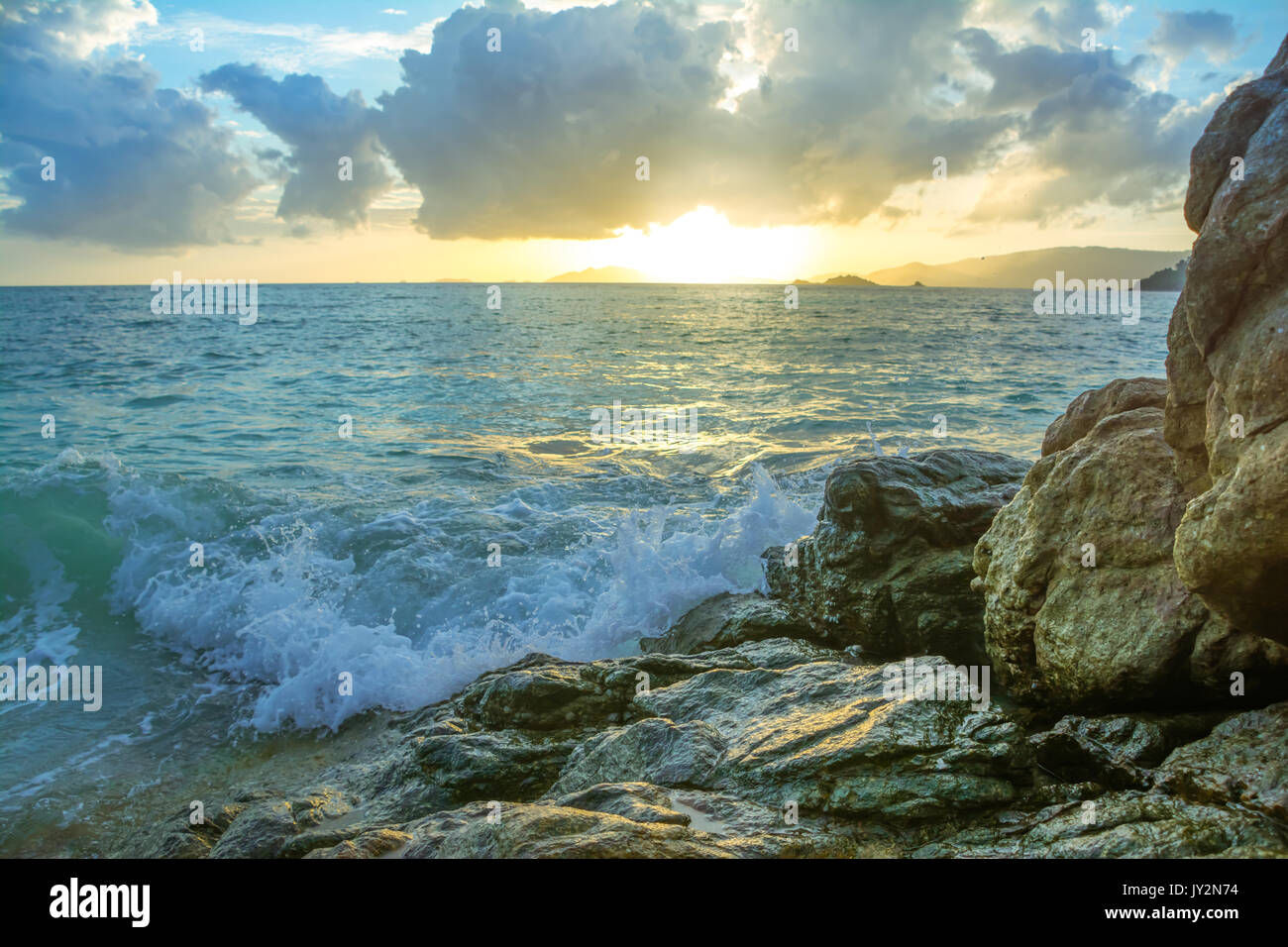Splash waves hit rocks with the beautiful sunset and sky Stock Photo ...