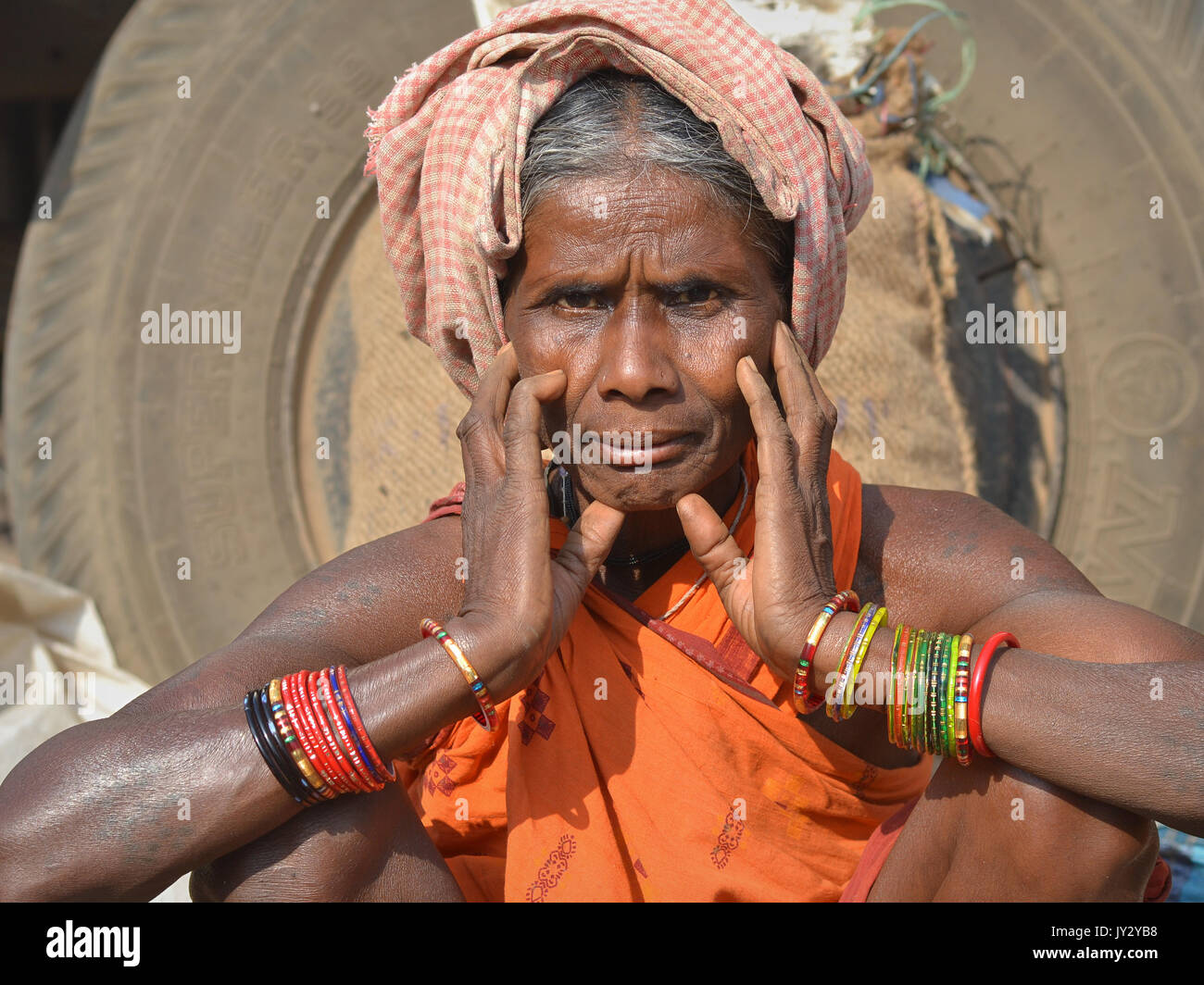 Old Indian Adivasi woman shows her colourful bangles. Stock Photo