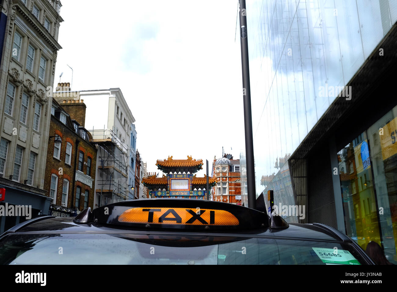 A London black cab at the entrance to Chinatown in Westminster Stock Photo