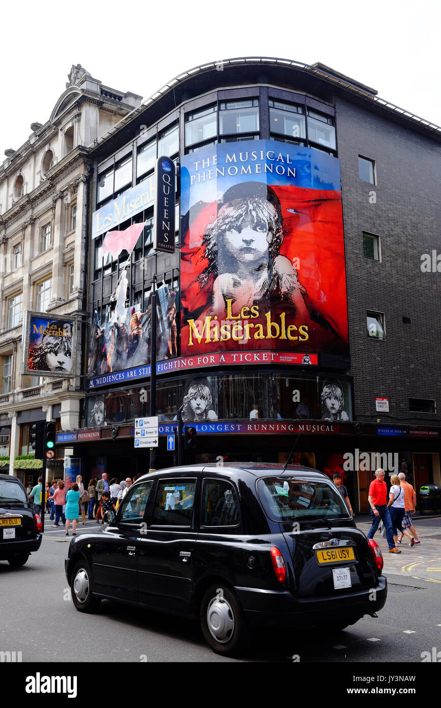 The Queen's Theatre in Shaftesbury Avenue, London hosting Les Miserables, a West End success with a black cab driving past Stock Photo