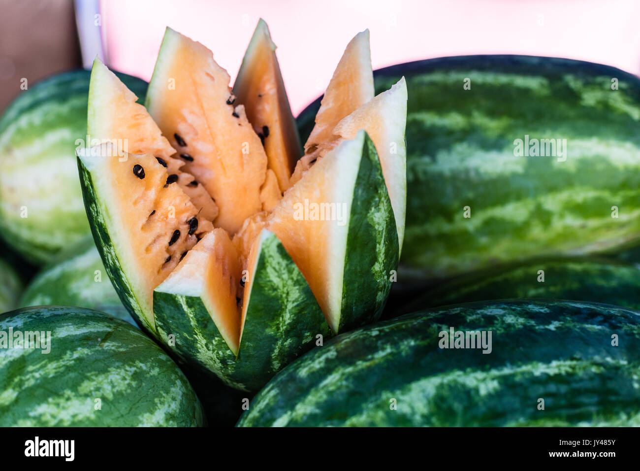 A sliced yellow watermelon at a farmers market display. Stock Photo