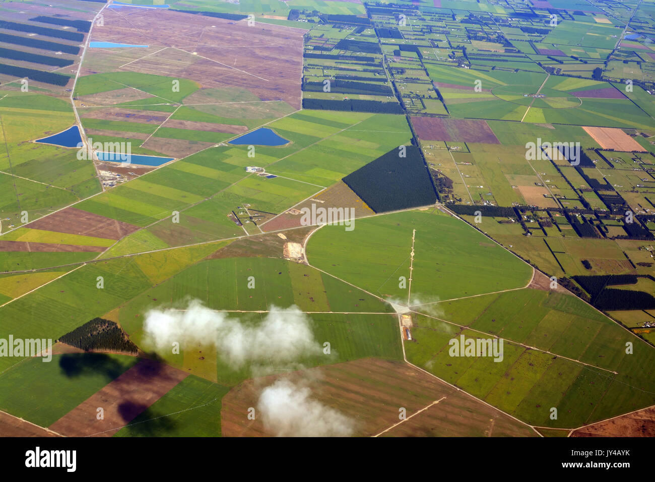 Closeup aerial view of Canterbury Plains as the mist clears on an Autumn morning, New Zealand. In the background are the Southern Alps. Stock Photo