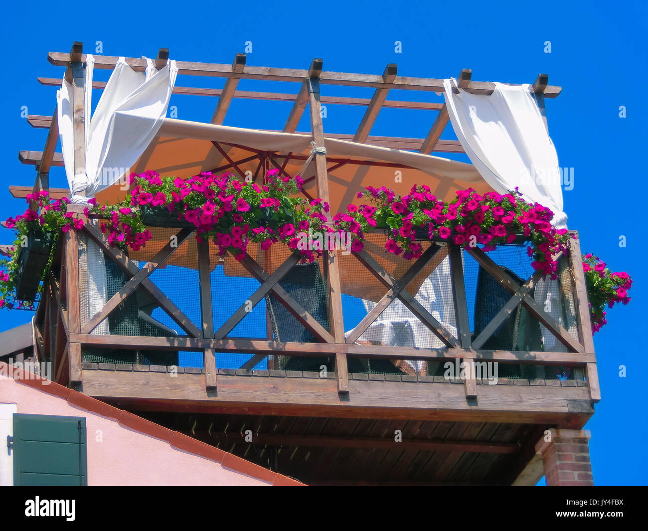 Burano, Italy - May 10, 2014: The original wooden veranda with table and chairs Stock Photo