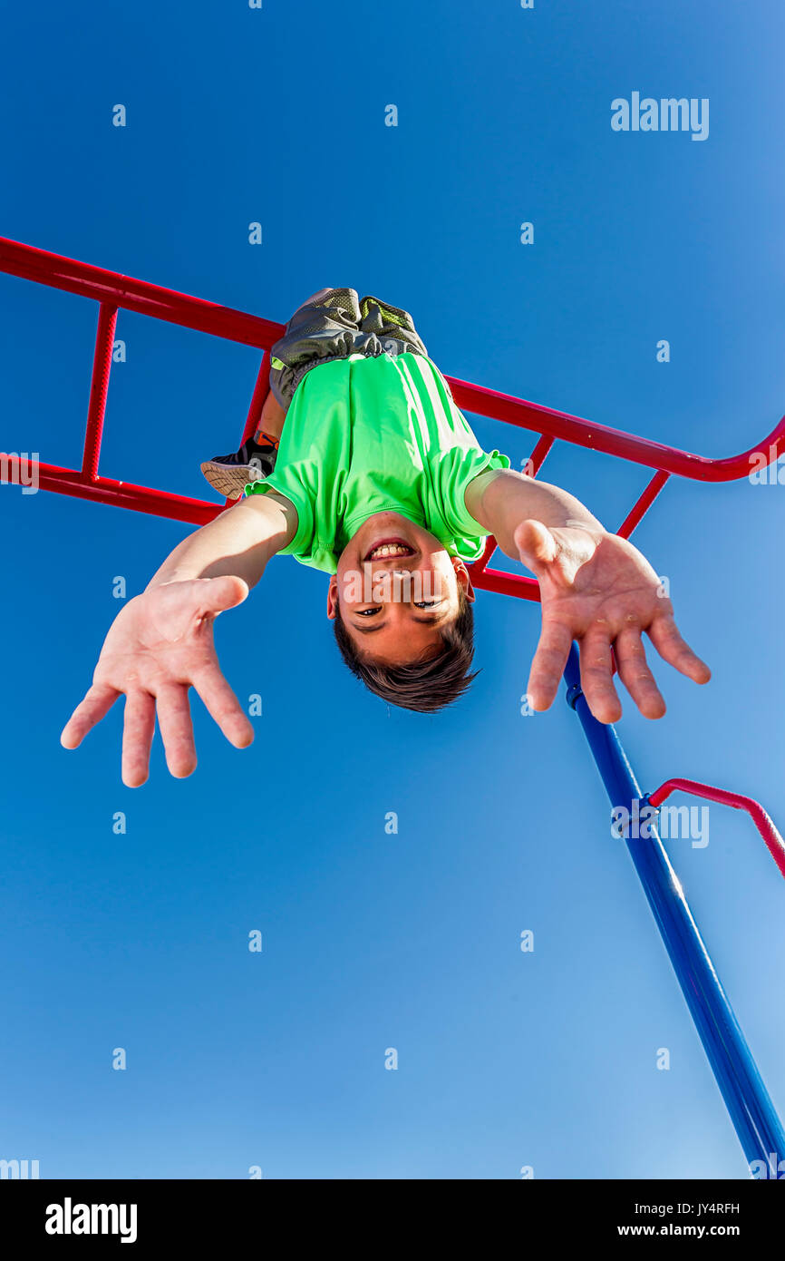 Девочка висит на турнике вниз головой. Лазить по деревьям. Ребенок висит вверх ногами. Висит на дереве. Вверх тормашками вверх ногами.