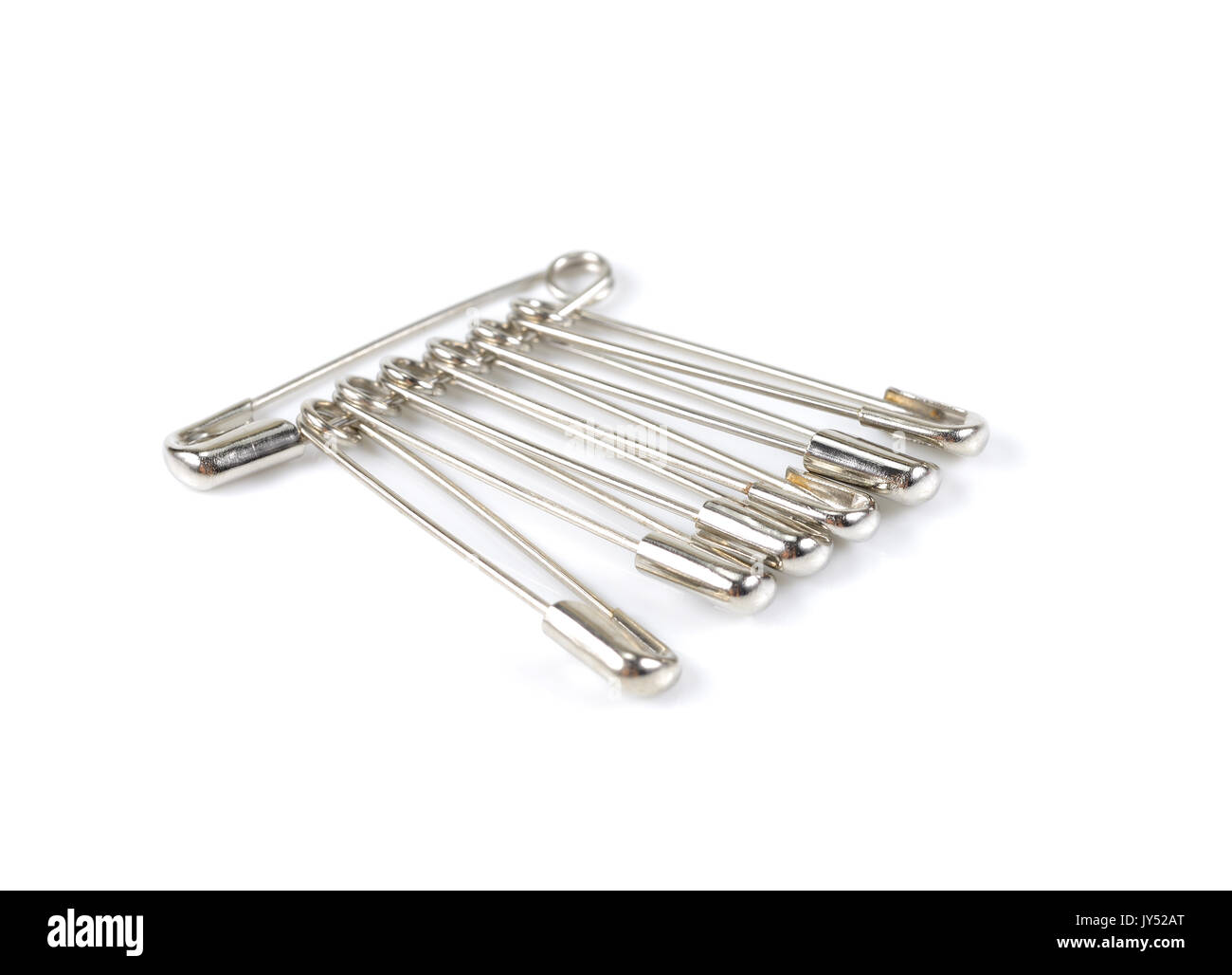 Bunch of safety pins on white background, shiny metal safety pin