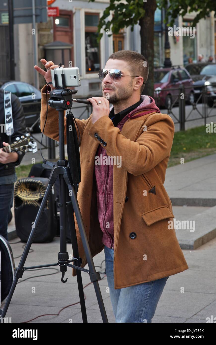 Man filming a street music group Stock Photo