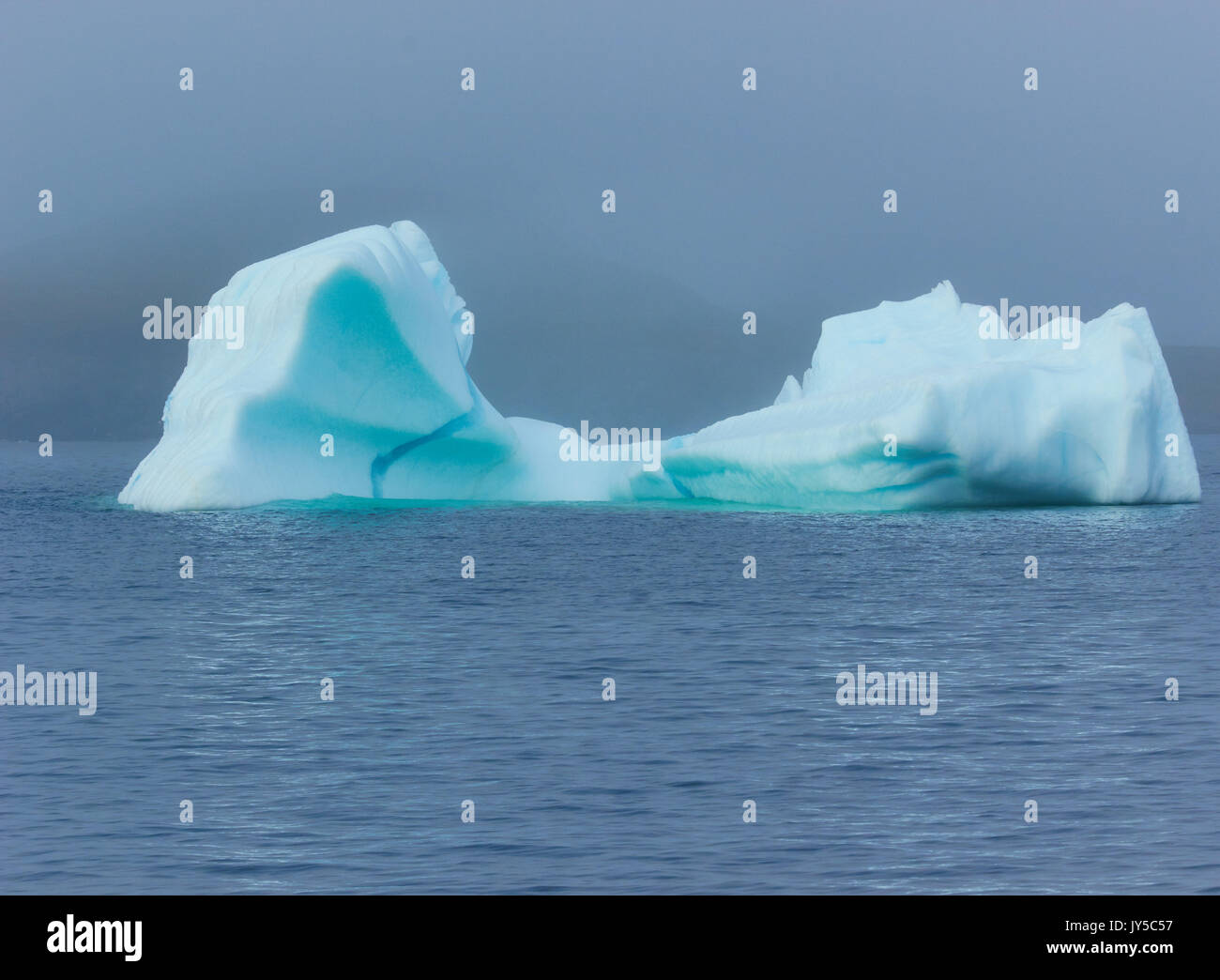 Blue iceberg off the shore of the community of St Lunaire Griquet at the tip of the Great Northern Peninsula, Newfoundland, Canada Stock Photo