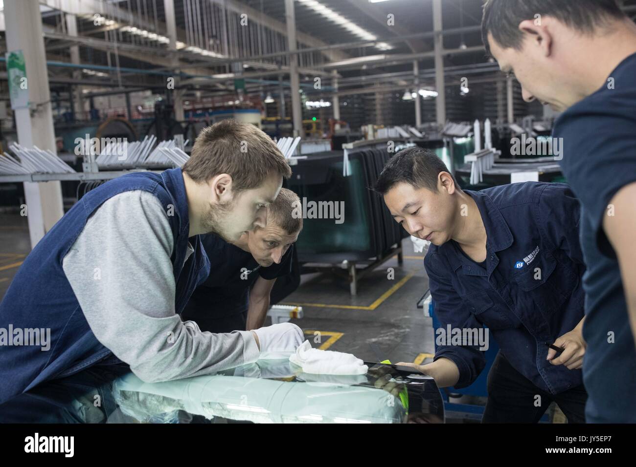 Kaluga, Russia. 18th July, 2017. Chinese and Russian workers work at an automobile-level float glass production line in the Russian factory of China's Fuyao Glass Industry Group Co. in Kaluga, Russia, July 18, 2017. Fuyao Group is a well-known Chinese enterprise that specializes in producing automobile safety glass and industrial technological glass. Fuyao invested in 2011 some 200 million U.S. dollars to build automobile-level float glass production lines in Kaluga. Credit: Wu Zhuang/Xinhua/Alamy Live News Stock Photo