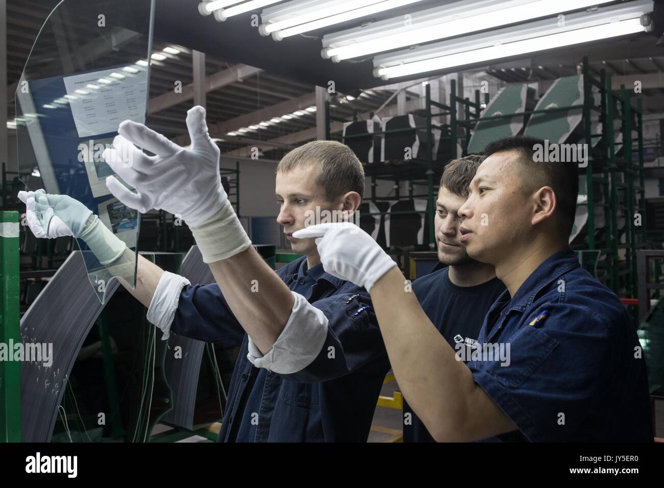 Kaluga, Russia. 18th July, 2017. Chinese and Russian workers work at an automobile-level float glass production line in the Russian factory of China's Fuyao Glass Industry Group Co. in Kaluga, Russia, July 18, 2017. Fuyao Group is a well-known Chinese enterprise that specializes in producing automobile safety glass and industrial technological glass. Fuyao invested in 2011 some 200 million U.S. dollars to build automobile-level float glass production lines in Kaluga. Credit: Wu Zhuang/Xinhua/Alamy Live News Stock Photo