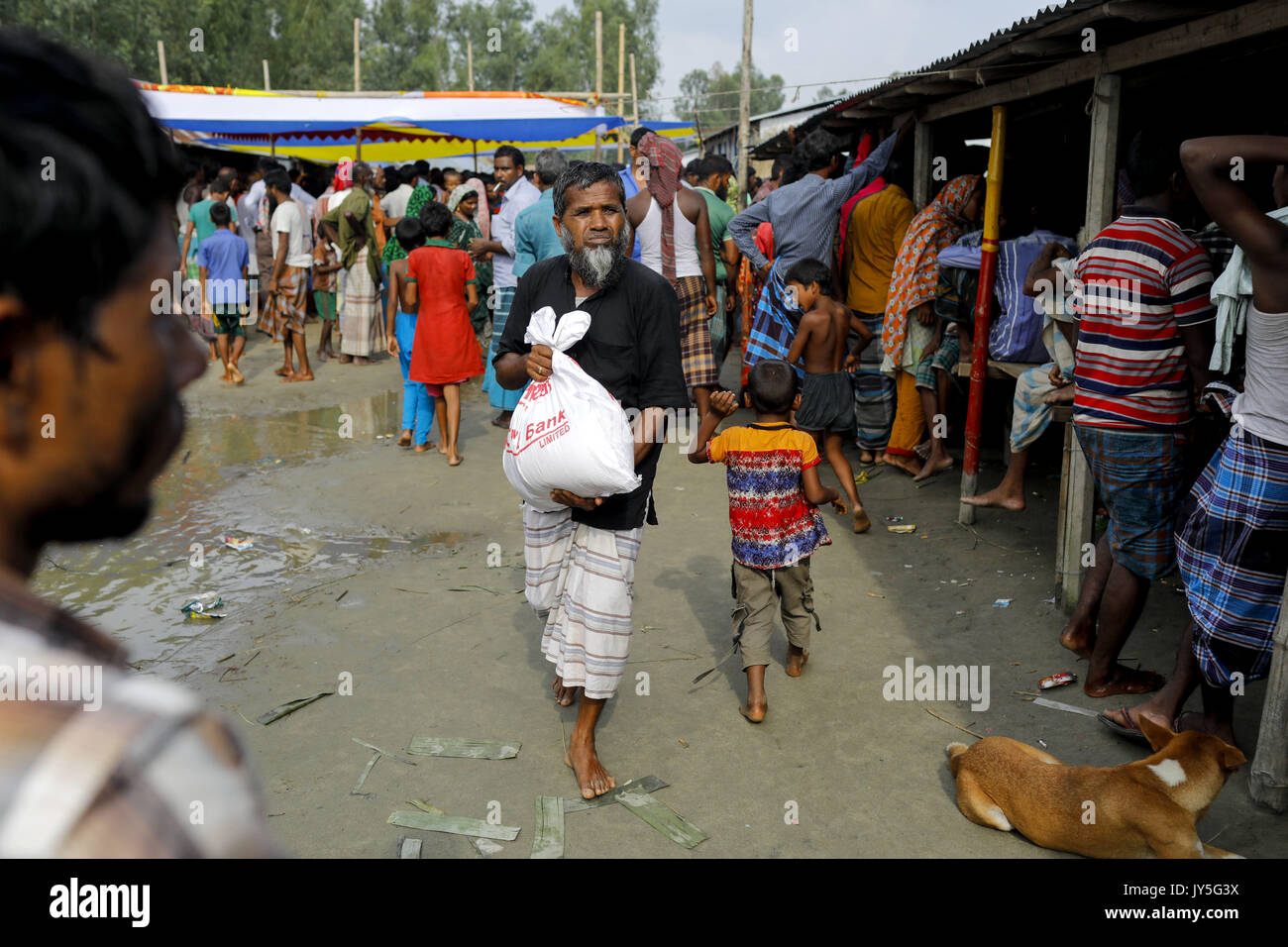 August 17, 2017 Bogra, Bangladesh. 17th Aug, 2017. Bangladeshi flood affected men receive relief from a local rulling party MP at Jamtola, Sariakandi, Bogra. According to authorities, floods caused by heavy rainfall lashing Bangladesh during the past week have left at least 56 people dead. Affected people are waiting to get more relief as they are in shortage of food and drinking water in the shelter centers. Credit: K M Asad/ZUMA Wire/Alamy Live News Stock Photo