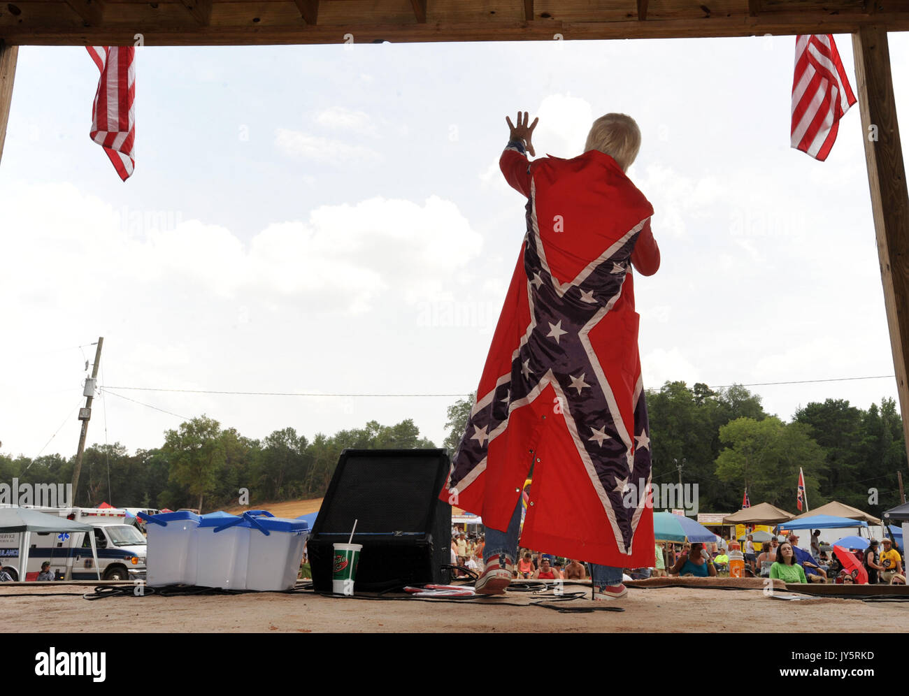 East Dublin, Georgia, USA. 11th Mar, 2008. Ronnie Mullis sports a Confederate Battle flag cape while performing at the 13th annual Summer Redneck Games at Buckeye Park in East Dublin, Georgia, on Saturday. The annual homage to Southerners, began as a spoof to the 1996 Summer Olympics in Atlanta. Thousands of revelers attend the event whose events include bobbing for pigs feet, the mud pit belly flop and armpit serenade. (Credit Image: © Erik Lesser/ZUMA Press) Stock Photo
