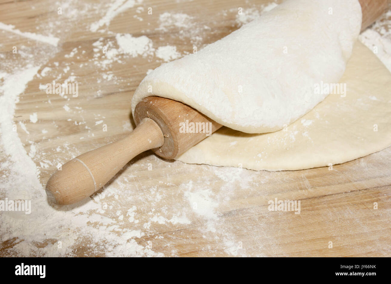 kitchen table with wheat flour, dough and roll for pizza or bread making Stock Photo