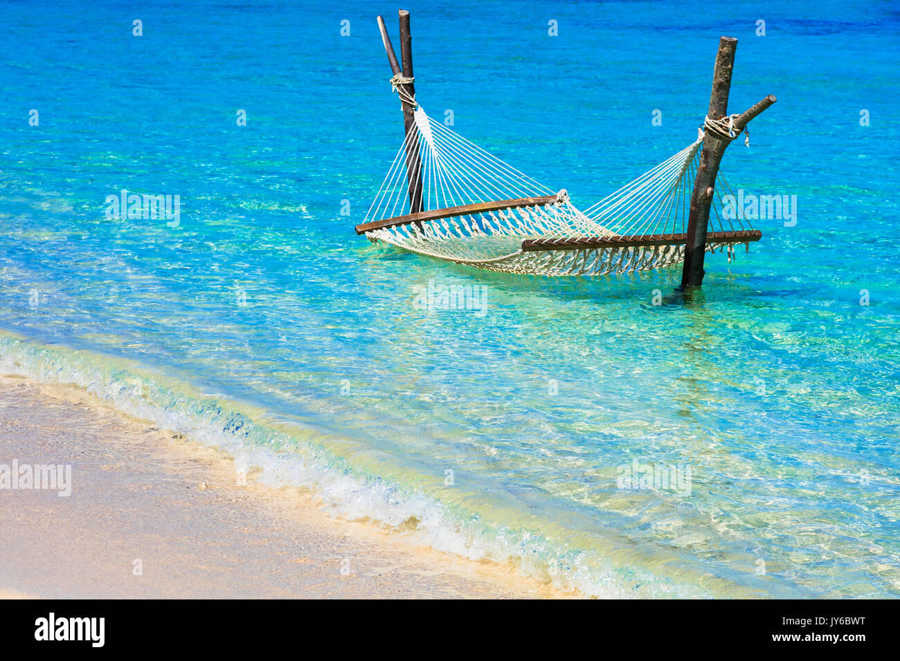 lasy tropical holidays. Hammock in turquoise sea. Stock Photo