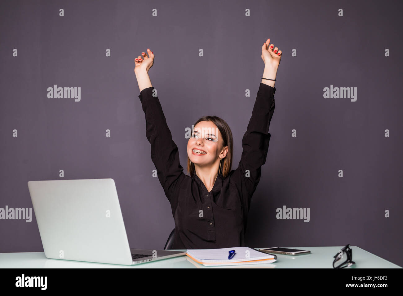 Young happy attractive woman at modern office desk, with laptop feeling great things on career horizon, saying yes to new adventures, cheerful good mo Stock Photo