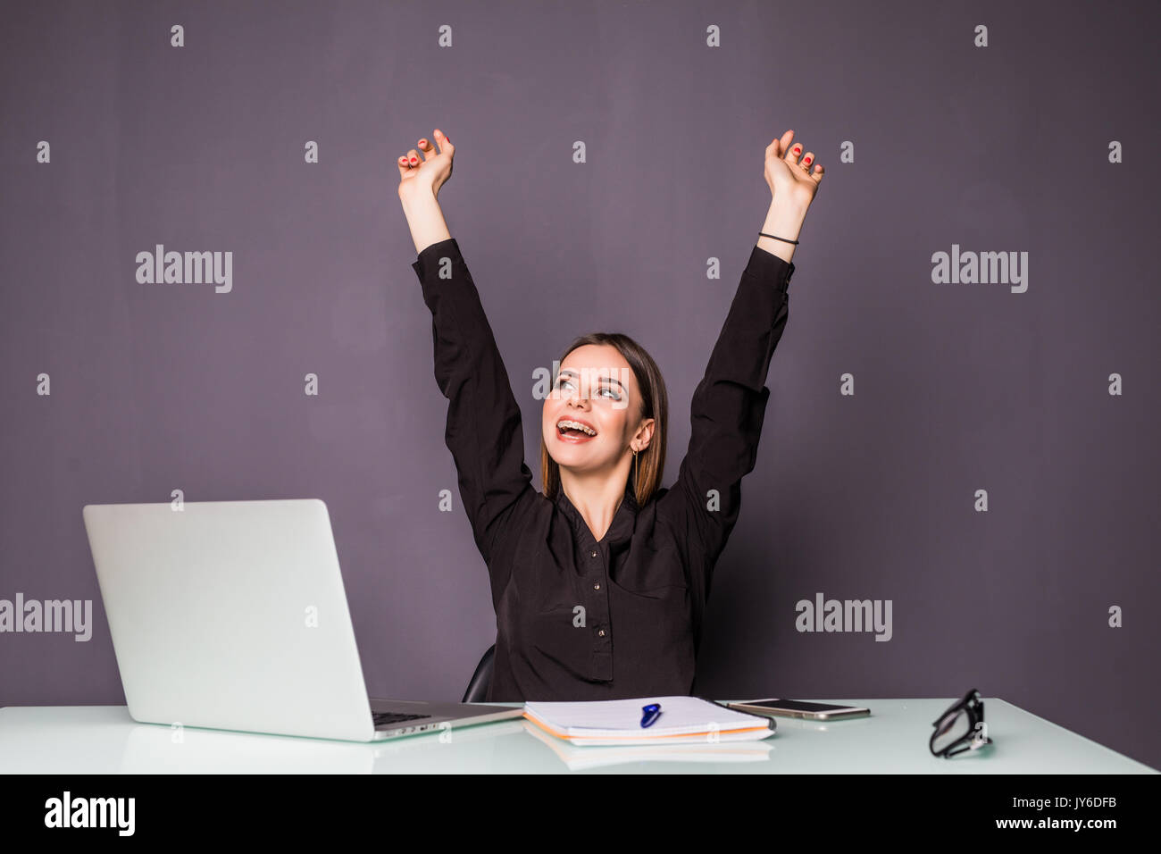 Young happy attractive woman at modern office desk, with laptop feeling great things on career horizon, saying yes to new adventures, cheerful good mo Stock Photo