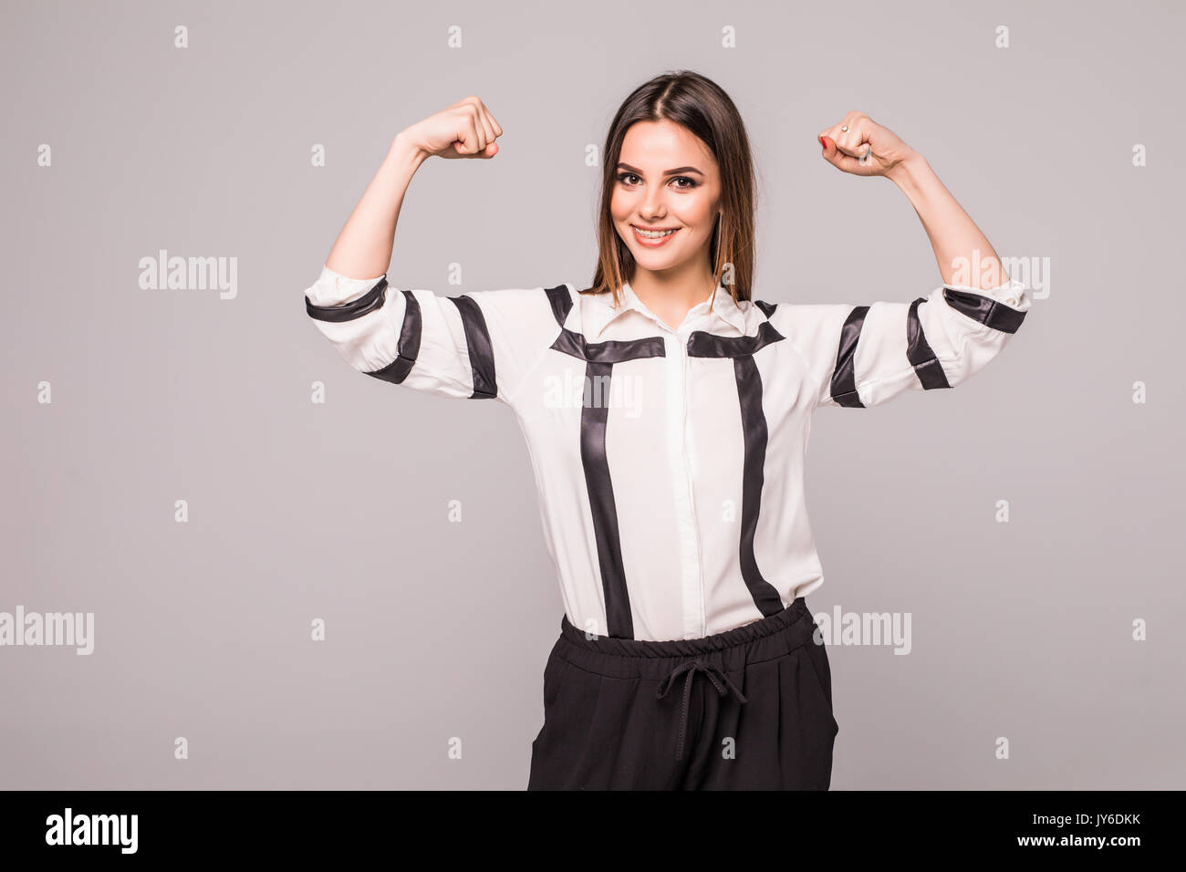 woman points to the strong hands on a gray Stock Photo