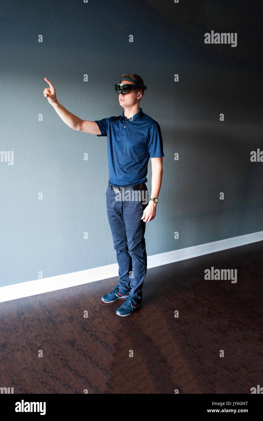 Young engineer in holographic headset creating a virtual surrounding using special gestures - gaze Stock Photo