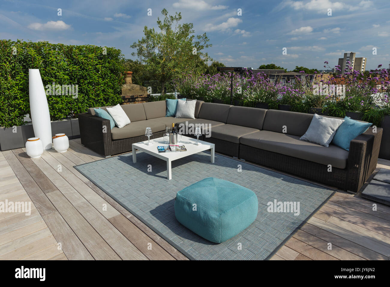 Luxurious roof terrace in London with hardwood timber decking, contemporary planters with lush planting and modern outdoor furniture Stock Photo