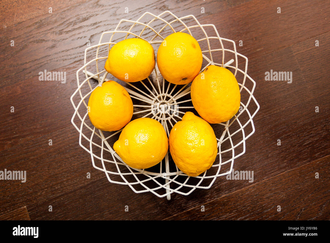 six lemon in a bowl from above on wooden  background Stock Photo