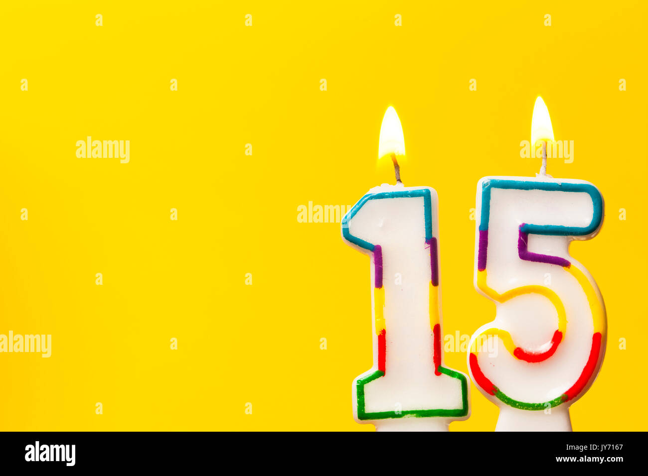 Number 15 Birthday Celebration Candle Against A Bright Yellow Number 15 Birthday Celebration Candle Against A Bright Yellow