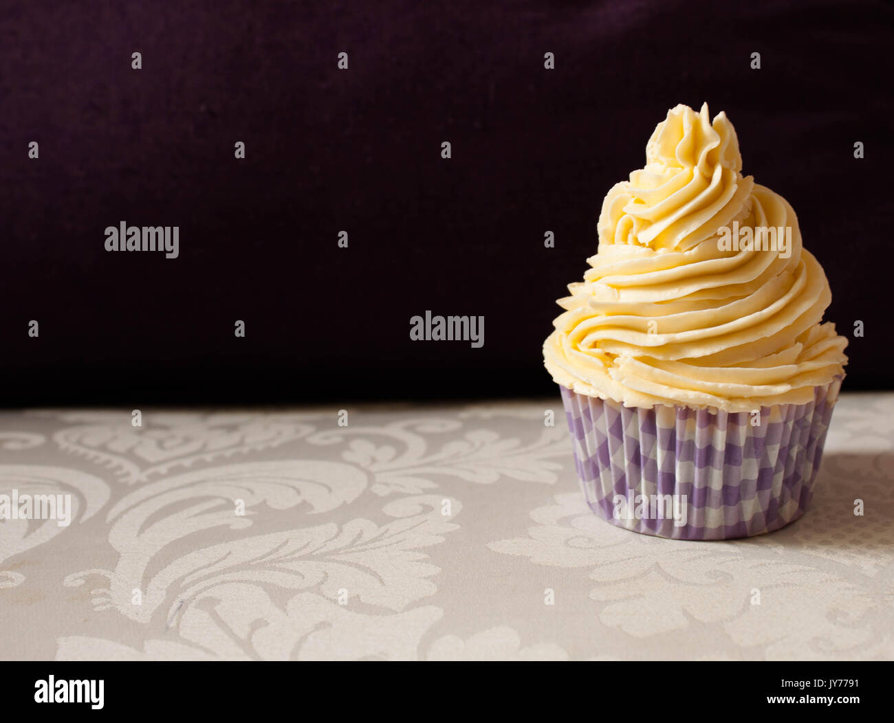 cupcake isolated with vanilla butter crean in abstract  purple and white background Stock Photo