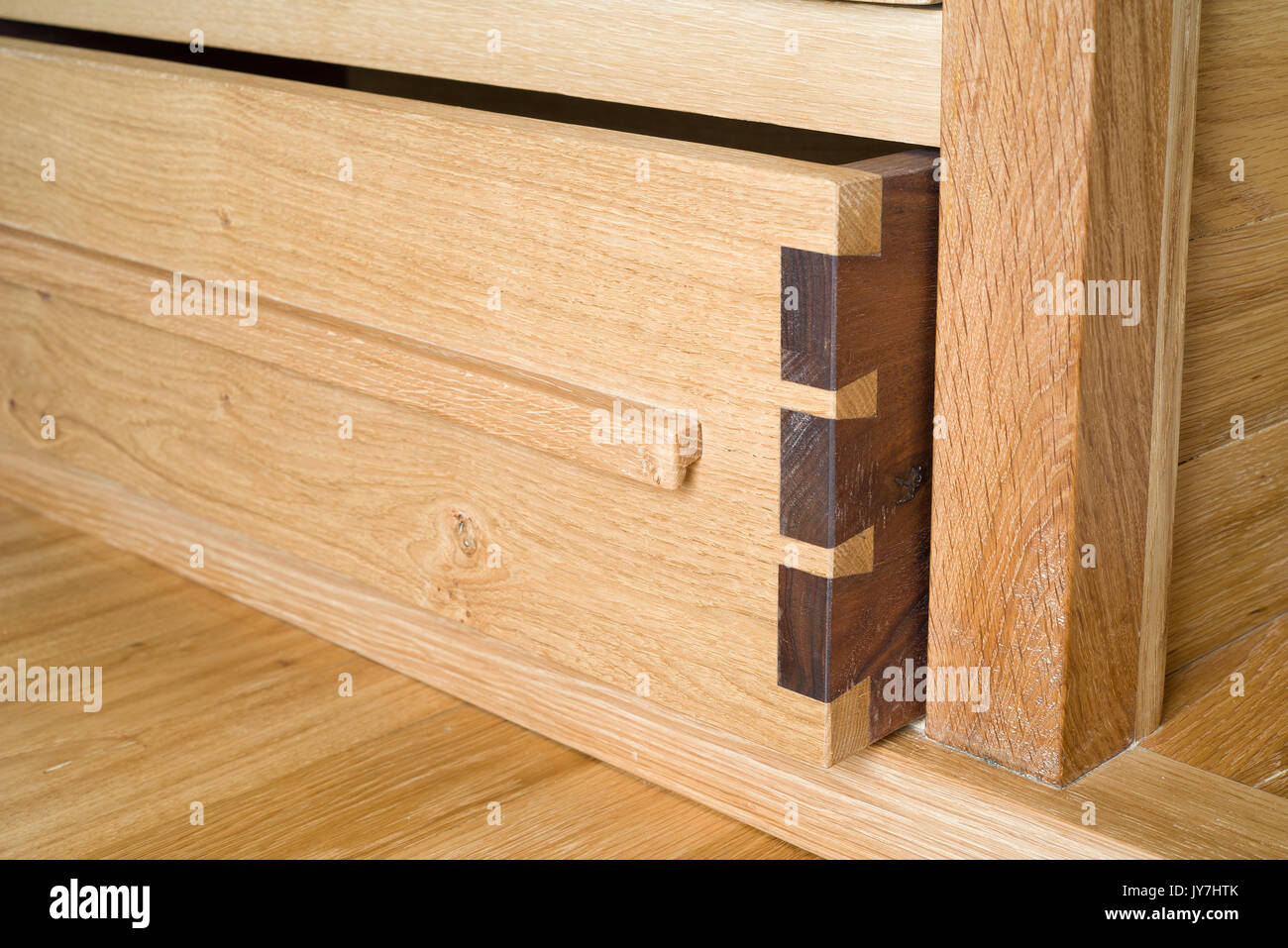 Wooden dovetail joint. Oak drawer. Carpenters skills. Stock Photo