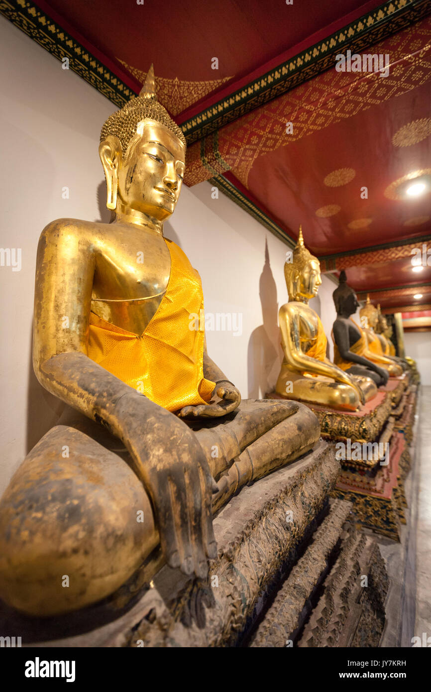 Row of praying golden sitting Buddhas at Wat Pho (Reclining Buddha Temple), Bangkok, Thailand Stock Photo