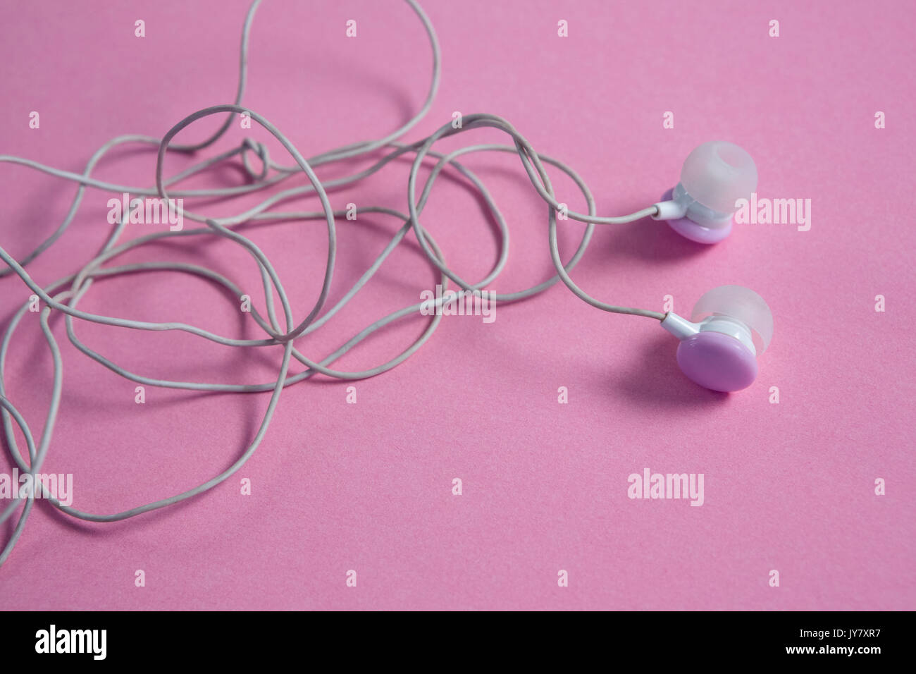 Close-up of pink earphones on pink background Stock Photo