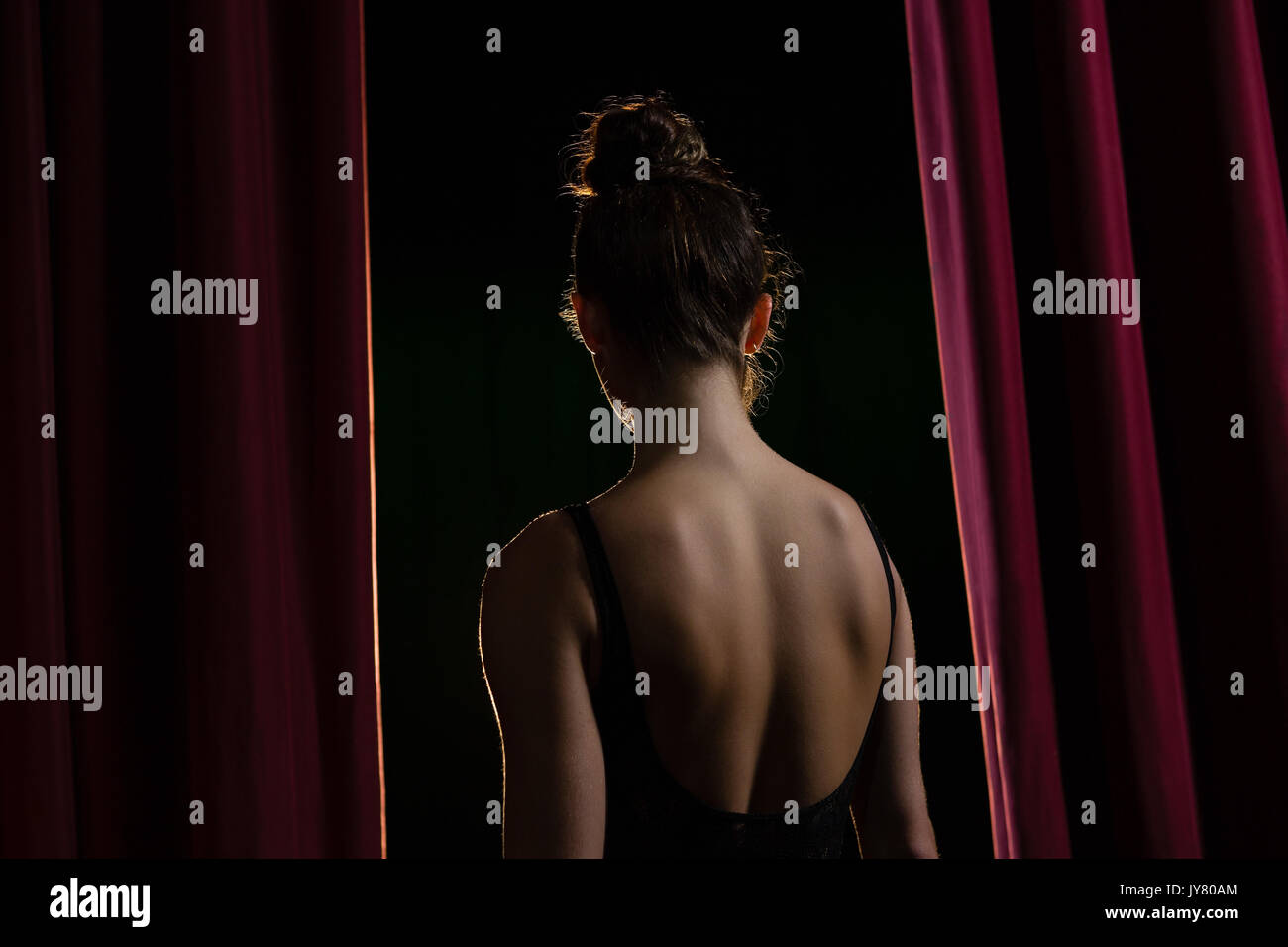 Rear view of ballerina performing ballet dance on stage in theatre Stock Photo