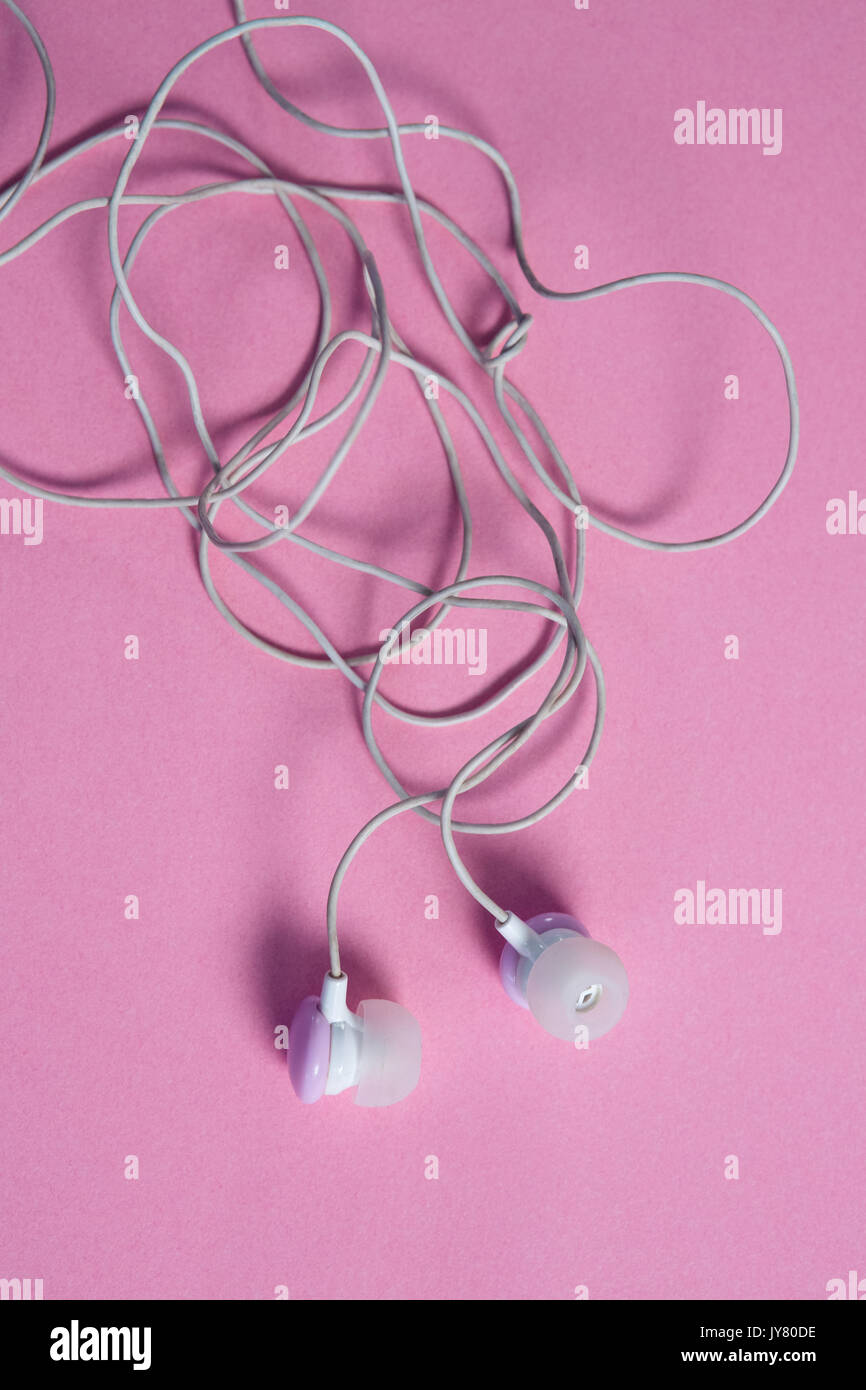 Close-up of pink earphones on pink background Stock Photo