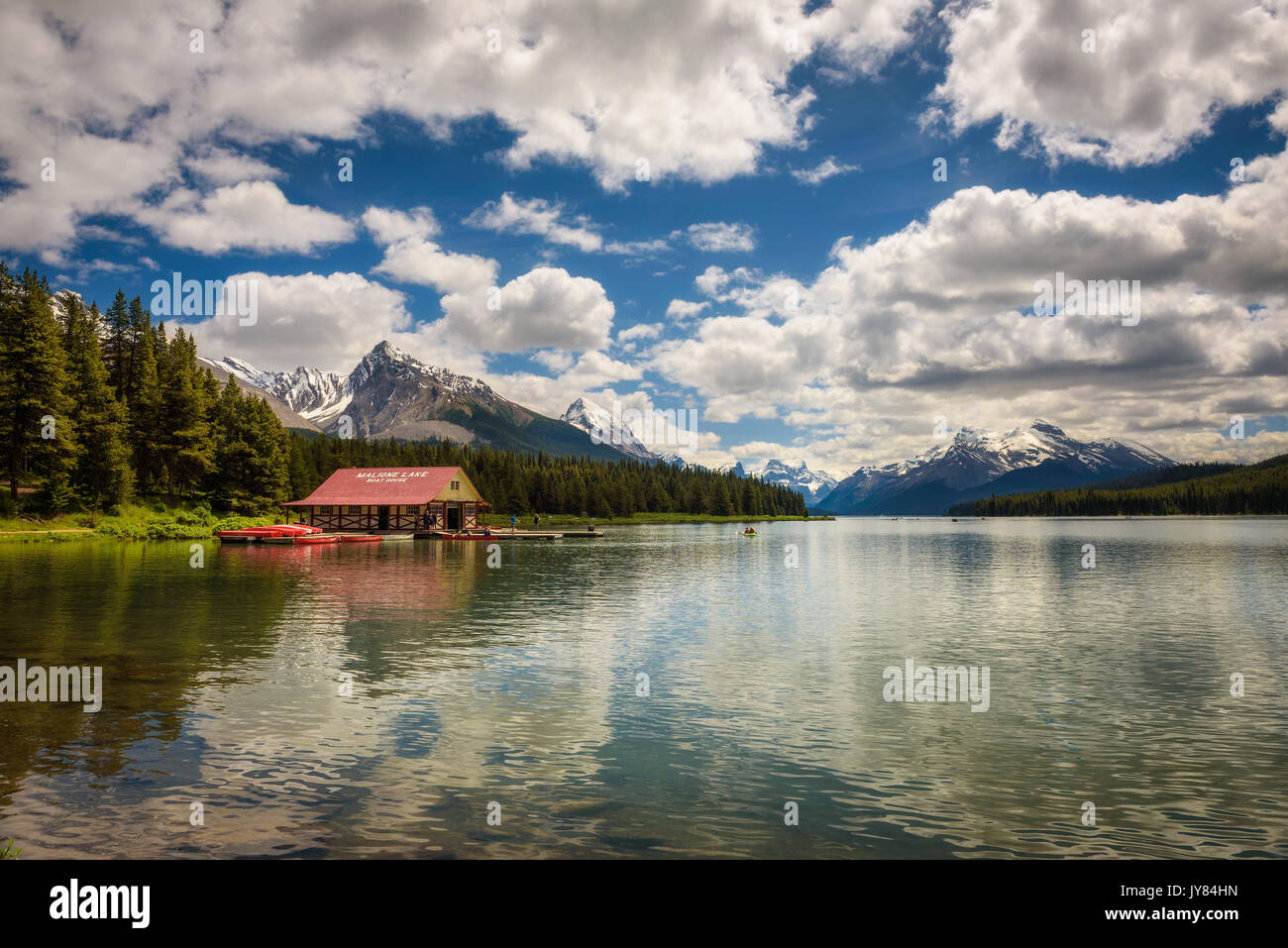 Boat house and the idyllic Maligne Lake in Jasper National Park, Canada, with snow-covered peaks of canadian Rocky Mountains in the background. Stock Photo