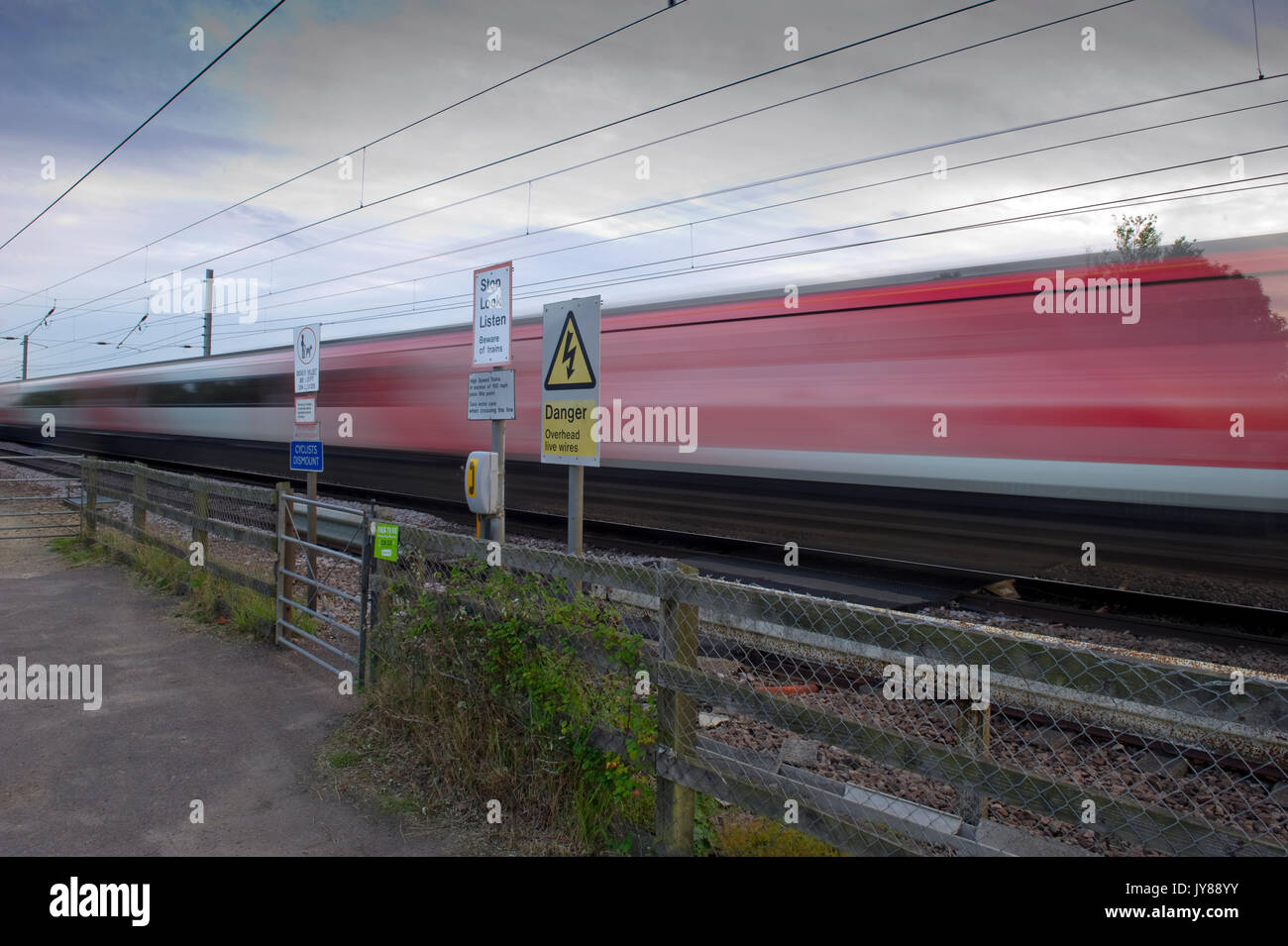 Trains at speed over pedestrian foot crossings on East Coast Main Line at Abbots Ripton, Cambridgeshire Stock Photo