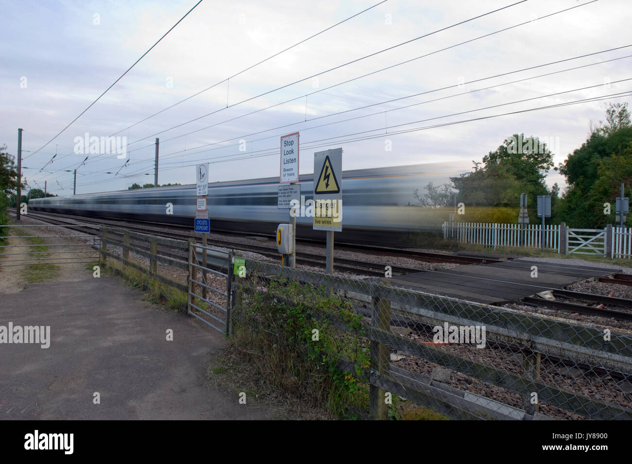 Trains at speed over pedestrian foot crossings on East Coast Main Line at Abbots Ripton, Cambridgeshire Stock Photo