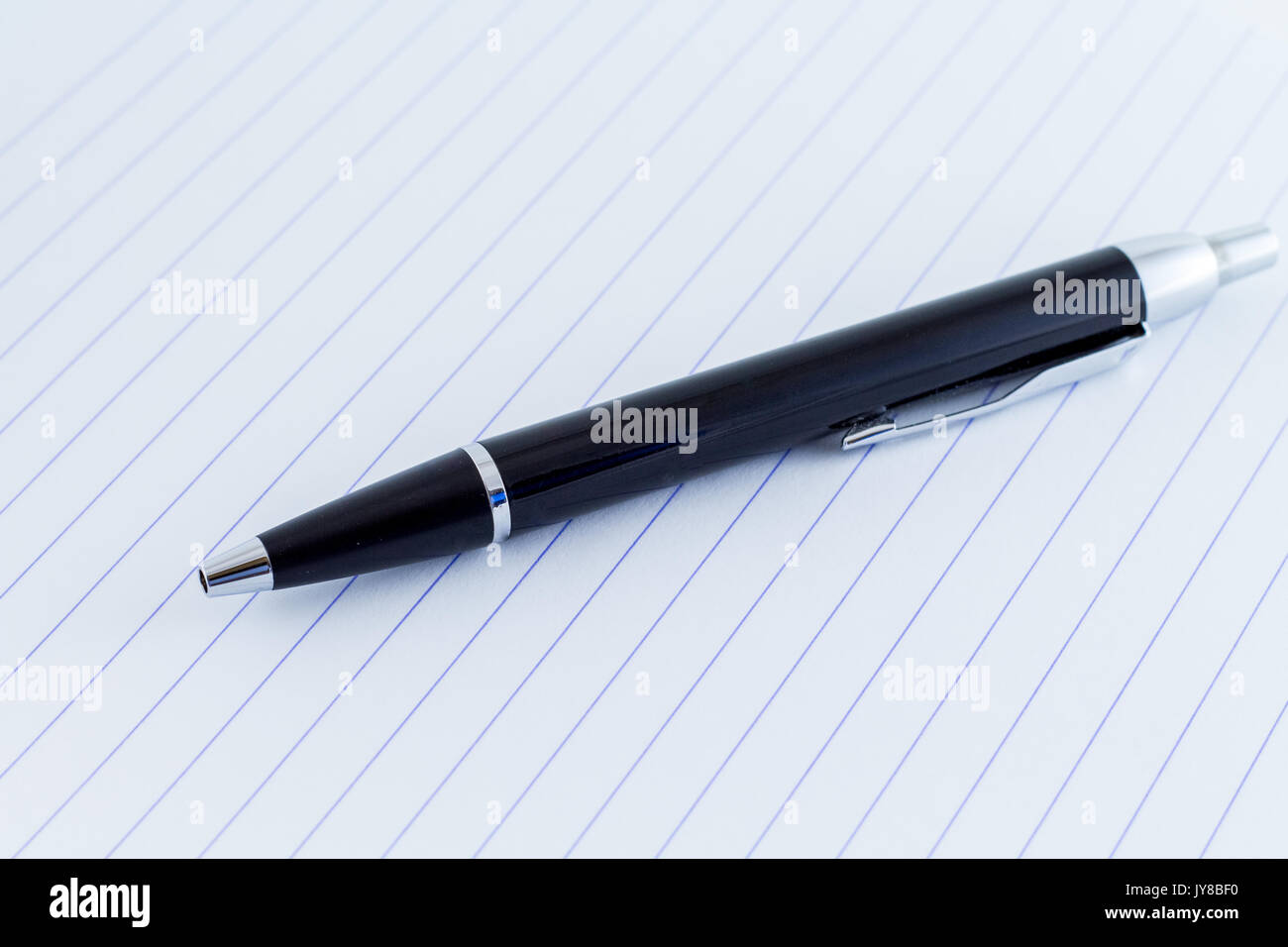 black writing pen on lines paper for writing Stock Photo