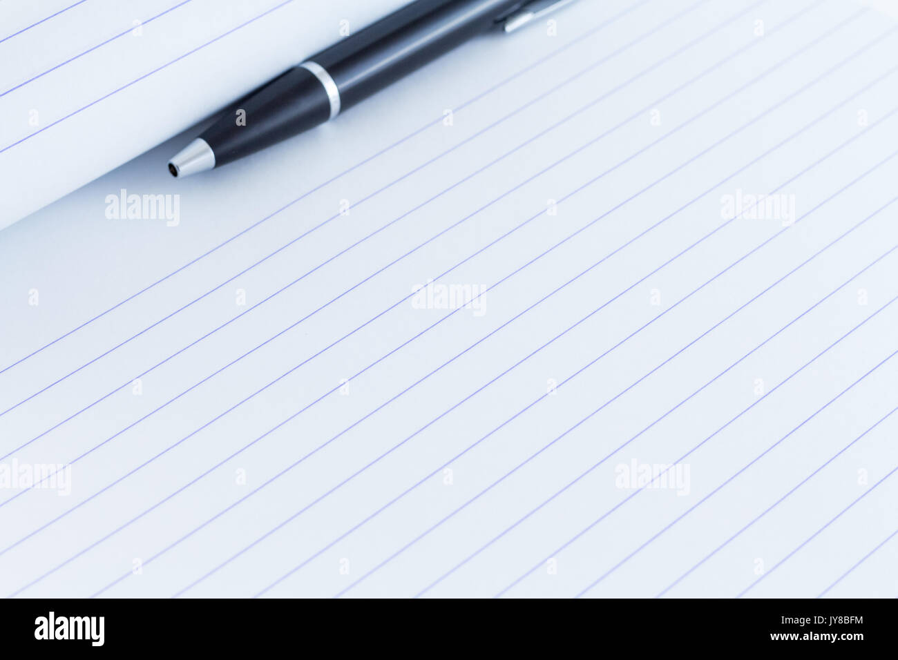 black writing pen on lines paper for writing Stock Photo