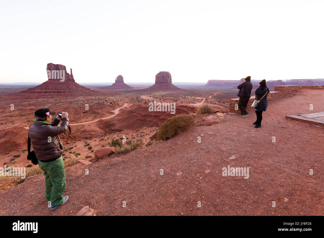 Monument Valley, Utah, USA. An Asian holidaymaker takes a photograph at Monument Valley as the sun begins to rise. Stock Photo