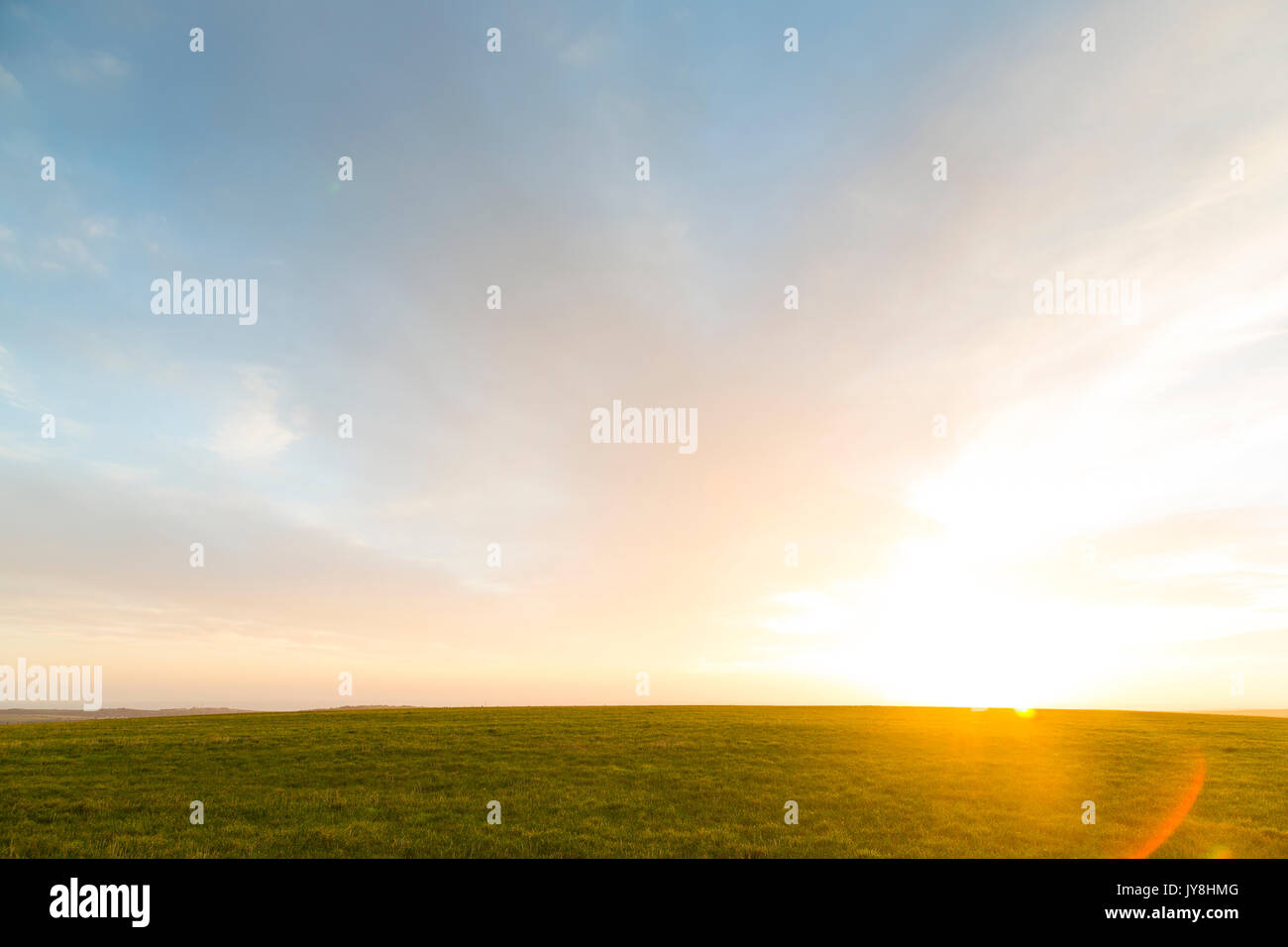 Ditchling Beacon, Sussex, UK. The sun prepares to set behind a rolling green field in Sussex. Stock Photo