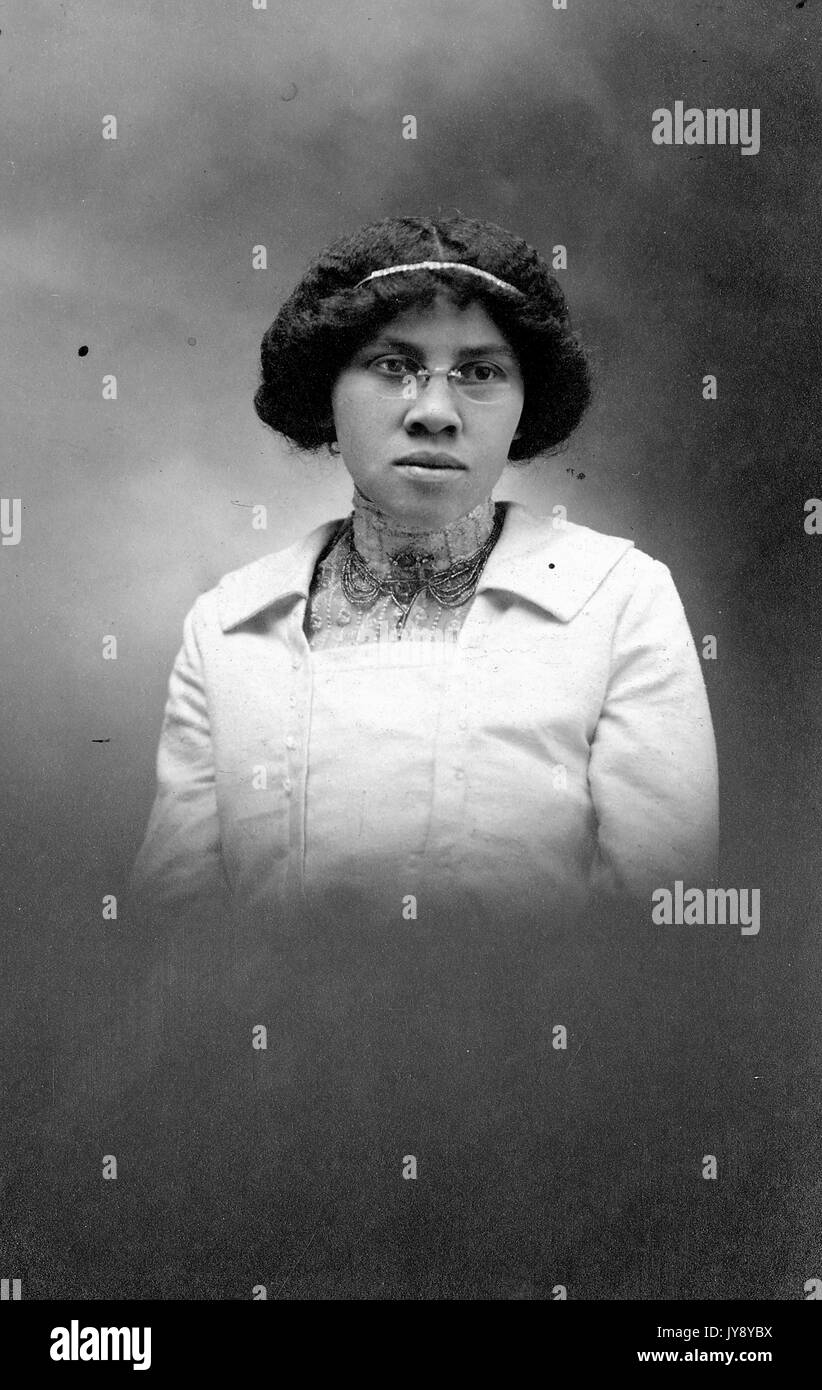 Half length portrait, African American woman, vignette style photograph, wearing white collared top, wearing embellished neckpiece, neutral facial expression, 1920. Stock Photo