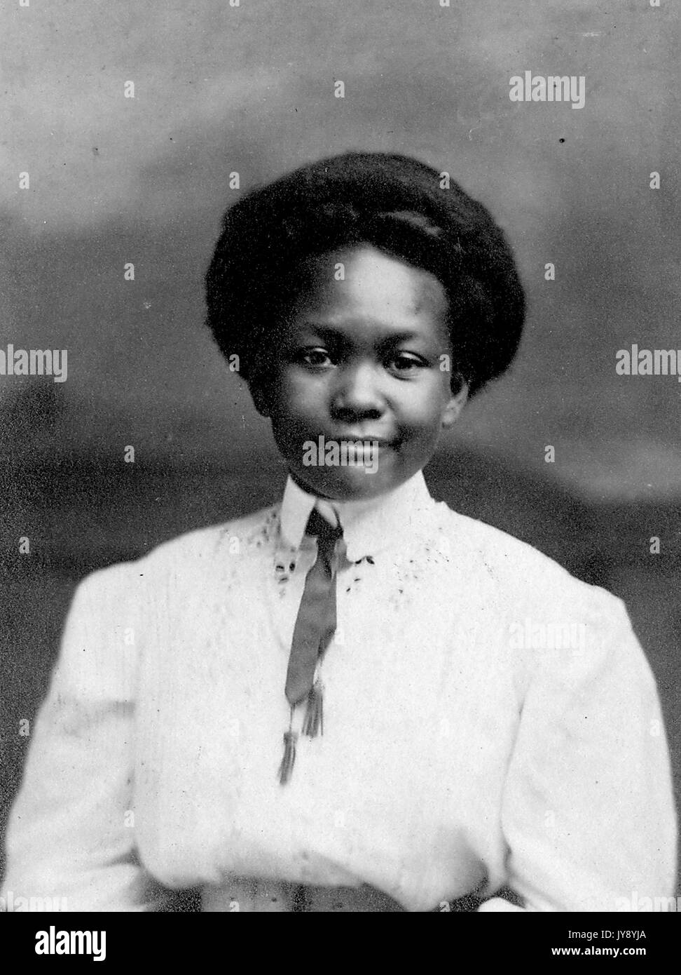 Half length portrait of African American woman wearing white collared top with ribbon tie, short hairdo, neutral facial expression, Lebanon, Missouri, 1915. Stock Photo