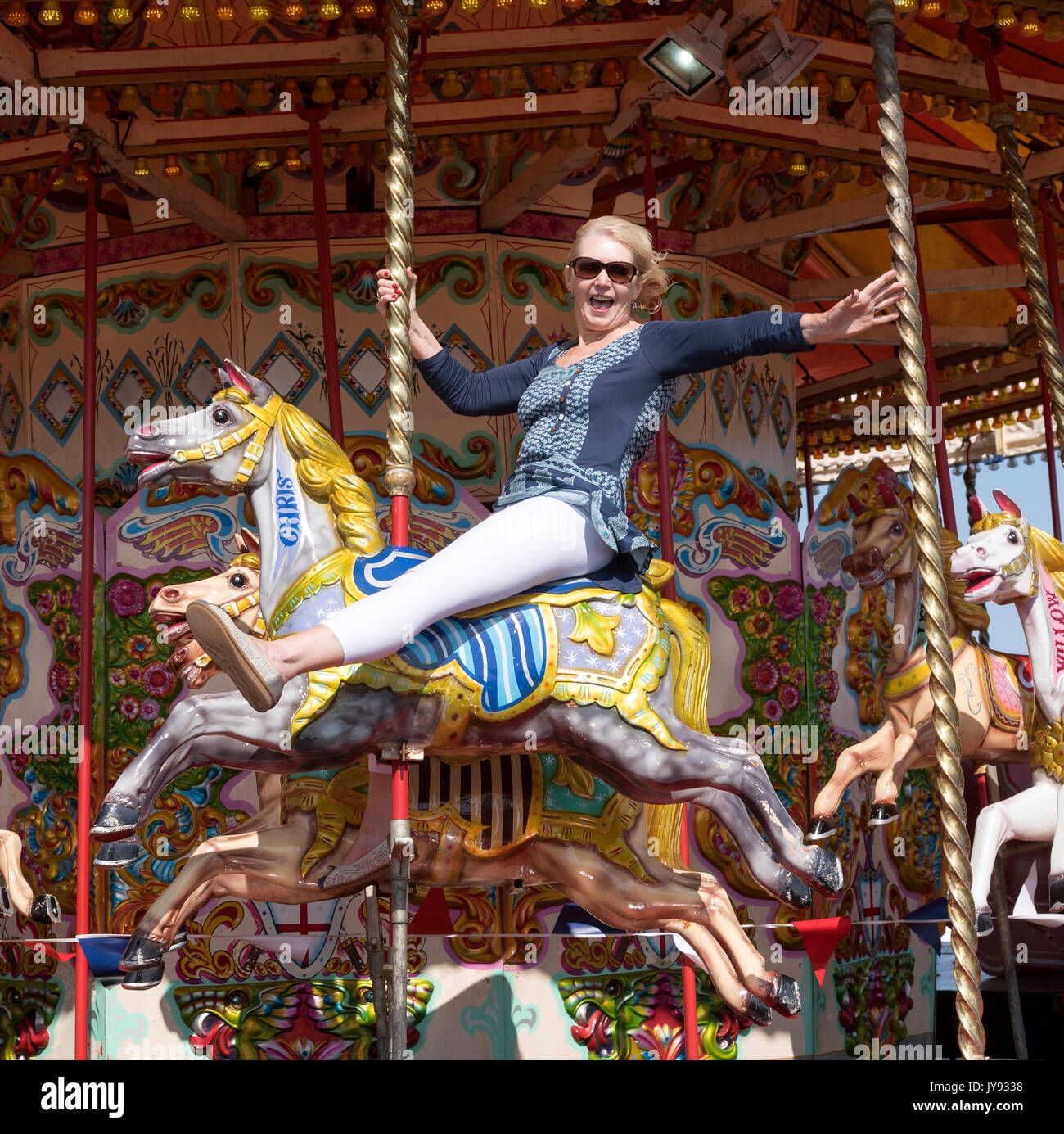 Woman riding a Carousel horse at the seaside Stock Photo Alamy