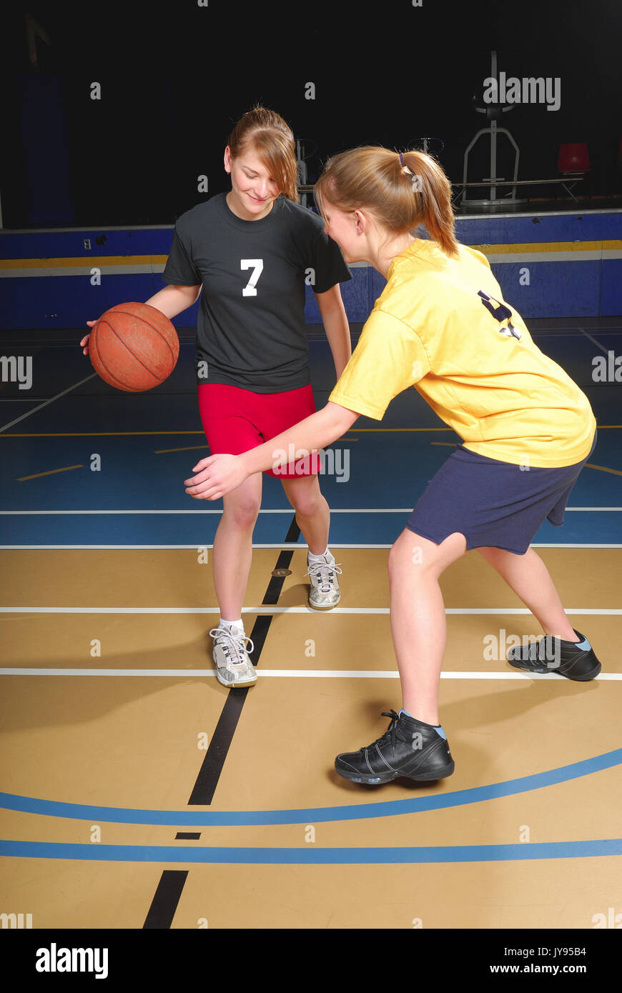 Two female basketball players compete in gym Stock Photo