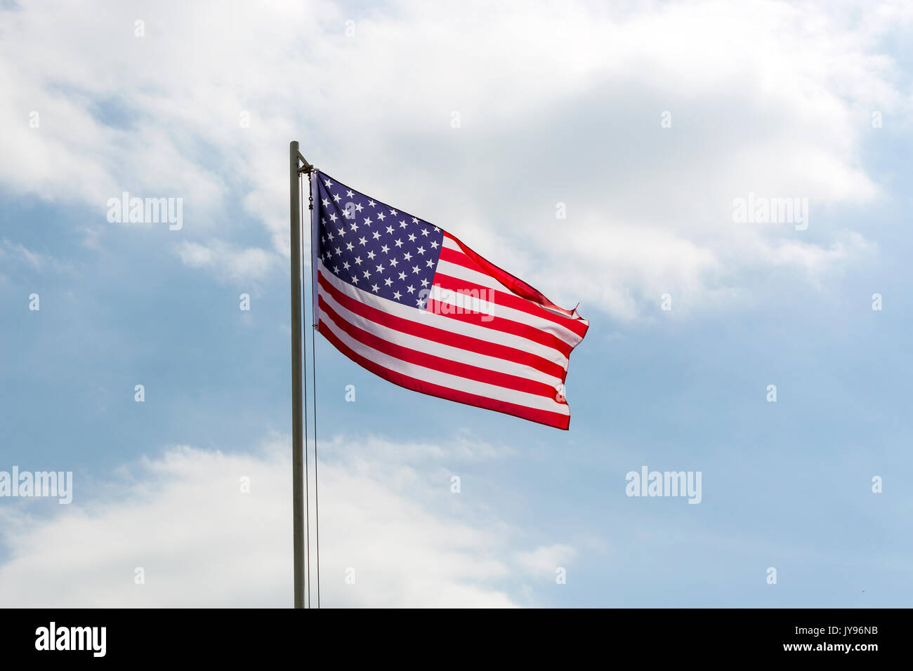 Flag of United States on a flagpole in front of blue sky Stock Photo ...
