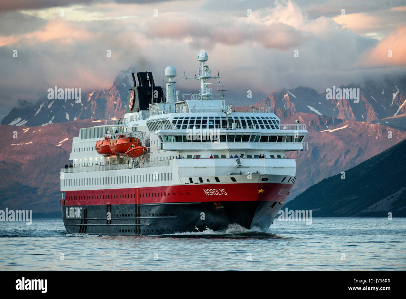 The Hurtigruten MV Nordlys approaches Tromso North of the Arctic Circle in Norway. Stock Photo